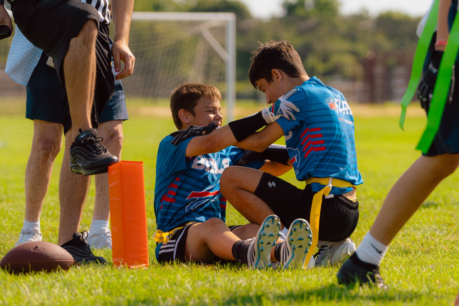 An ALL HEART player helping a teammate up off the field